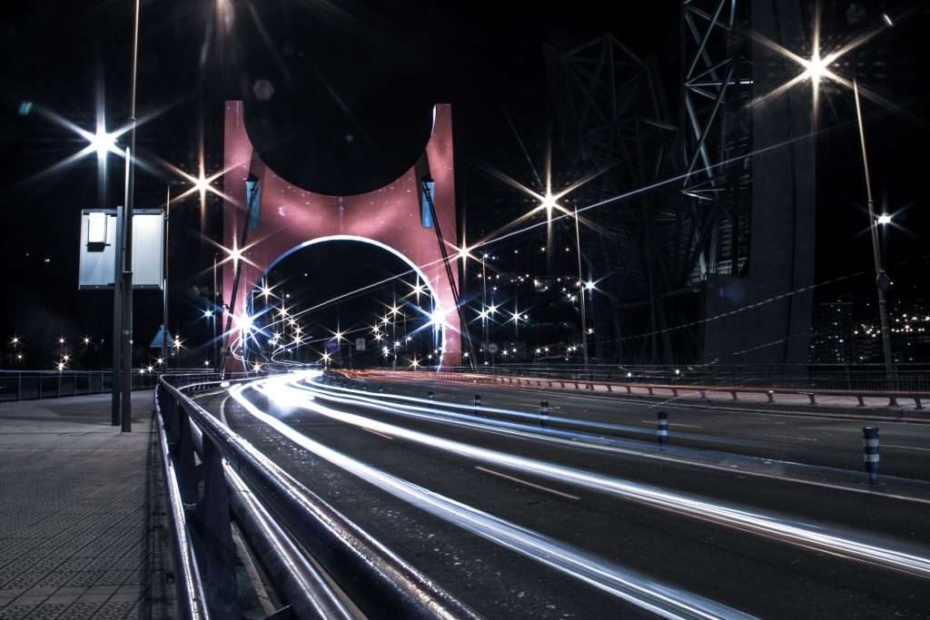 Langzeitbelichtung der beleuchteten Brücke nahe dem Guggenheim-Museum in Bilbao bei Nacht.